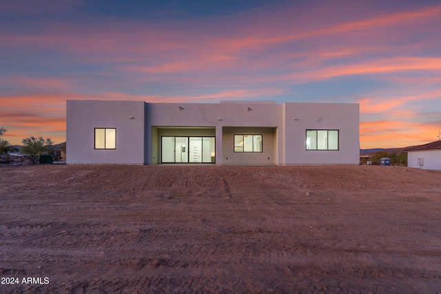 view of back house at dusk