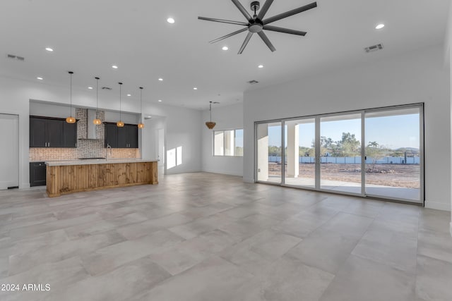 unfurnished living room featuring ceiling fan and a water view