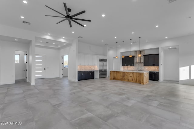 unfurnished living room with plenty of natural light and ceiling fan