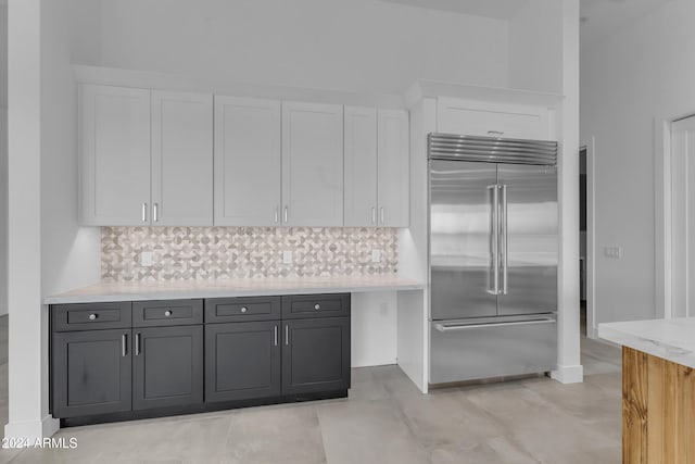 kitchen featuring tasteful backsplash, gray cabinetry, stainless steel built in fridge, and white cabinets