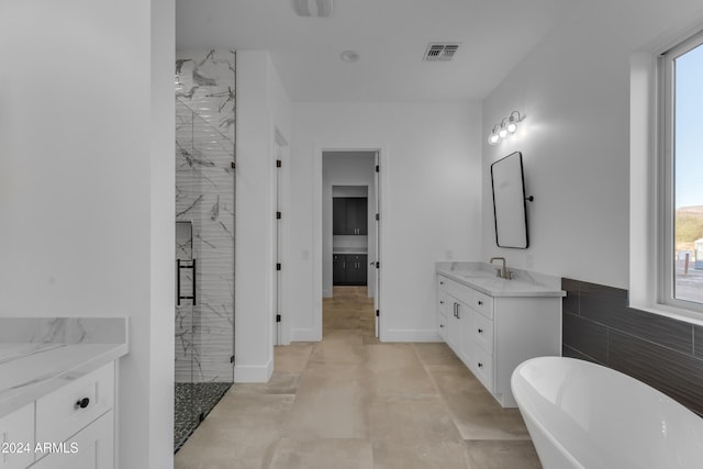 bathroom featuring vanity, tile walls, and independent shower and bath