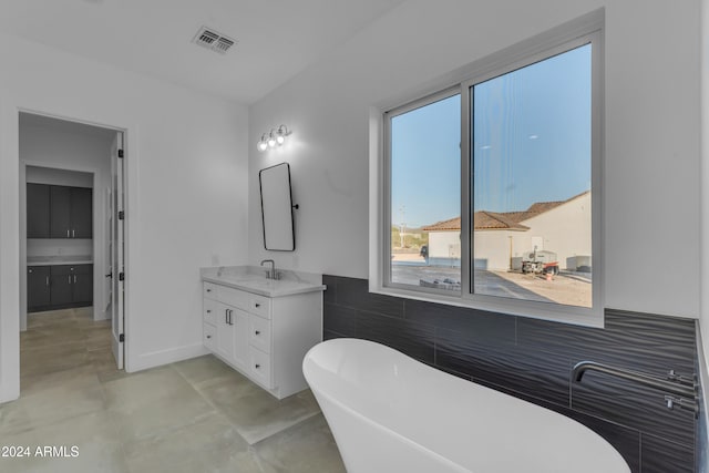 bathroom with vanity and a bath