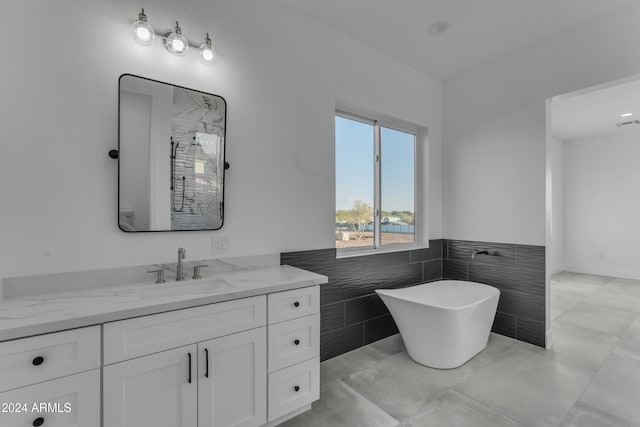 bathroom with tile patterned flooring, vanity, tile walls, and independent shower and bath