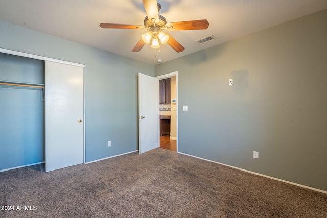 unfurnished bedroom featuring a closet, ceiling fan, and dark colored carpet