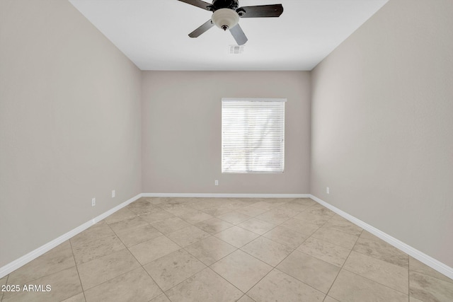 spare room with ceiling fan and light tile patterned floors