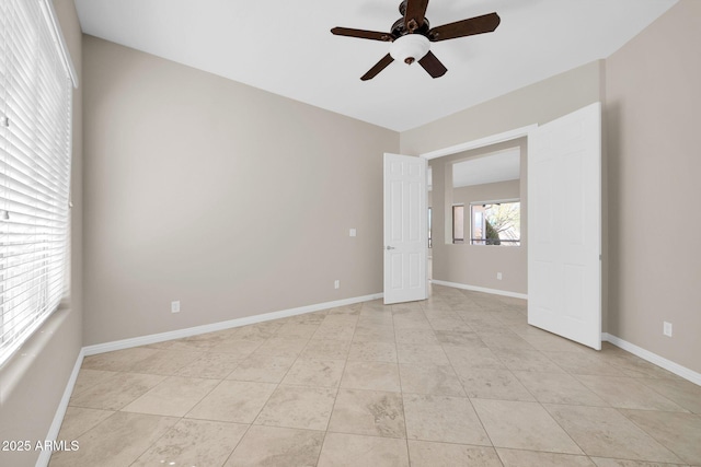 tiled spare room featuring ceiling fan