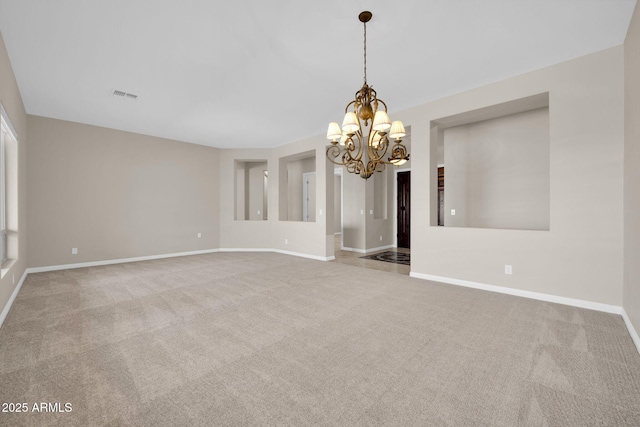 carpeted spare room with a notable chandelier