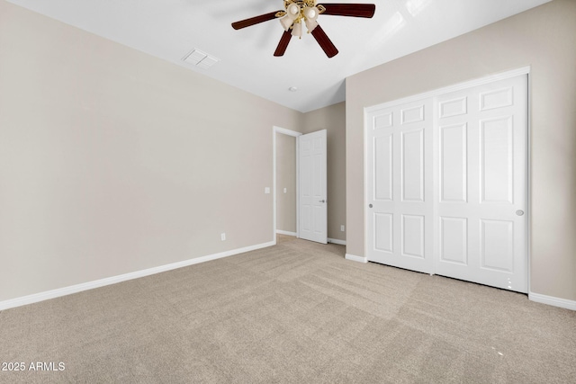 unfurnished bedroom with light carpet, a closet, and ceiling fan