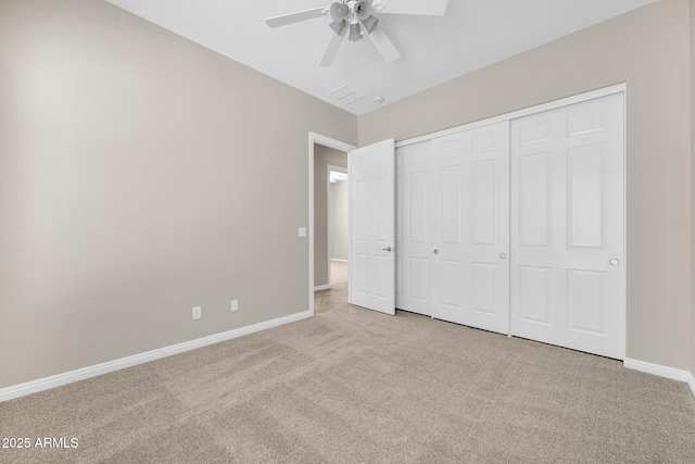 unfurnished bedroom featuring light colored carpet, ceiling fan, and a closet