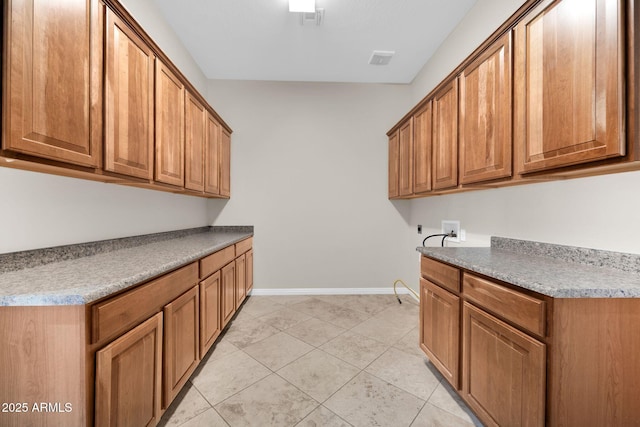 washroom featuring cabinets, washer hookup, and light tile patterned floors