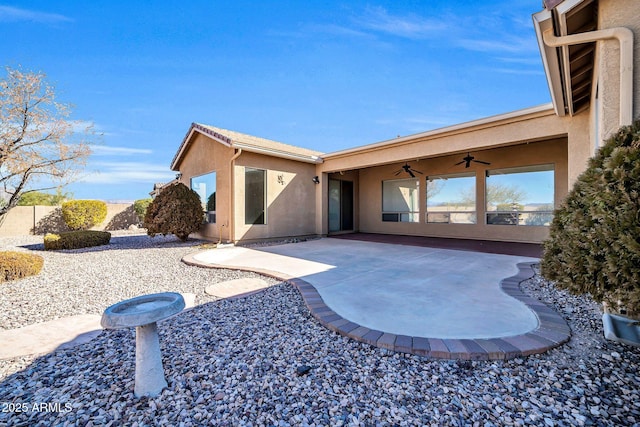 back of property featuring ceiling fan and a patio