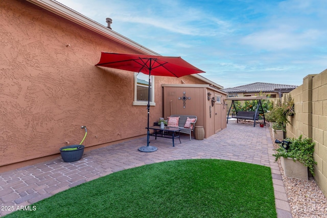 view of patio with a storage unit