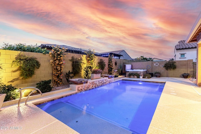 pool at dusk with a hot tub and a patio