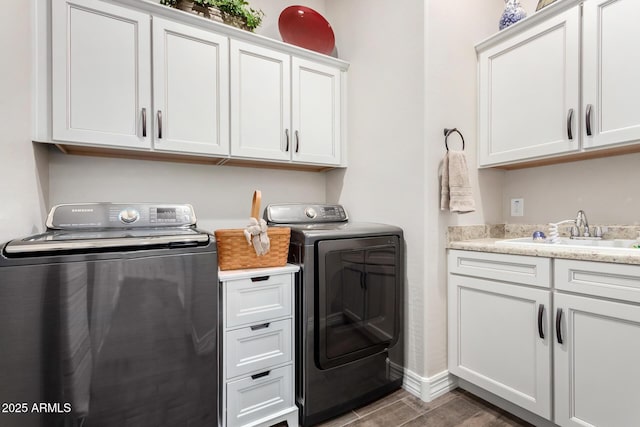 laundry room with cabinets, independent washer and dryer, and sink