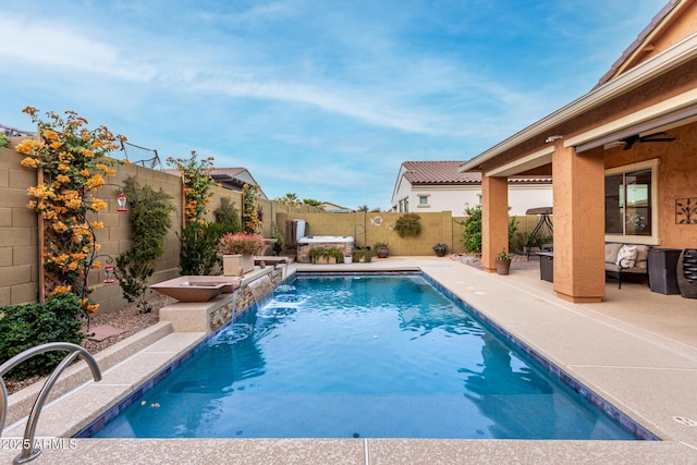 view of pool with pool water feature, ceiling fan, and a patio area