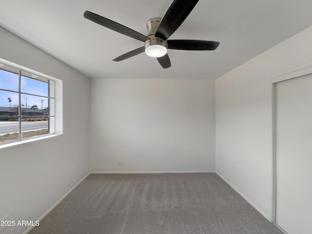 unfurnished room featuring a ceiling fan, carpet flooring, and baseboards