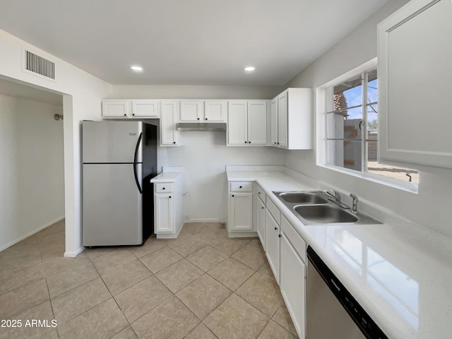 kitchen with visible vents, white cabinets, stainless steel appliances, light countertops, and a sink