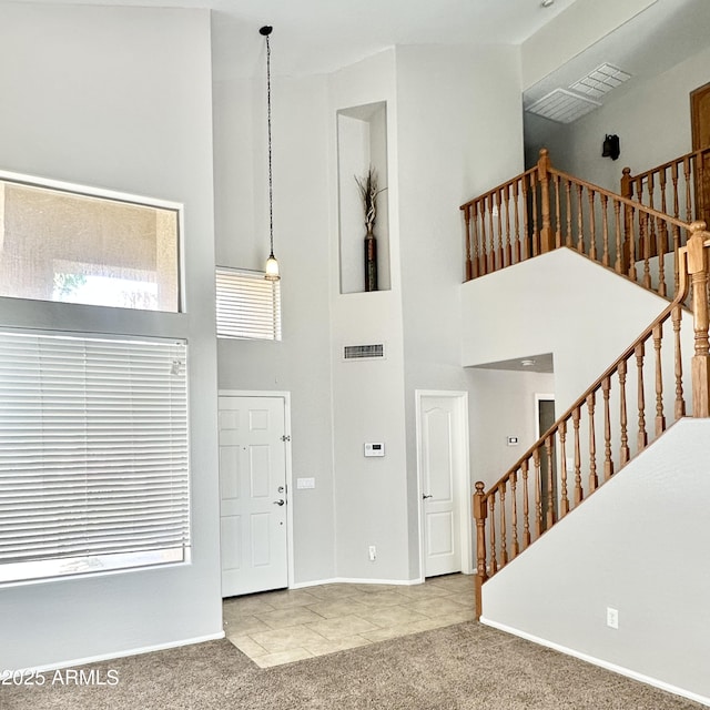 7117 W Globe Ave, Phoenix, AZ 85043 - entrance foyer featuring visible vents, stairs, a towering ceiling, baseboards, and carpet