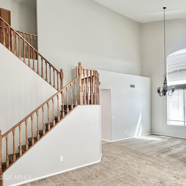 7117 W Globe Ave, Phoenix, AZ 85043 - staircase with carpet floors, visible vents, baseboards, a high ceiling, and a notable chandelier