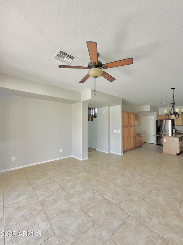 7117 W Globe Ave, Phoenix, AZ 85043 - unfurnished living room with baseboards, ceiling fan with notable chandelier, a textured ceiling, and visible vents