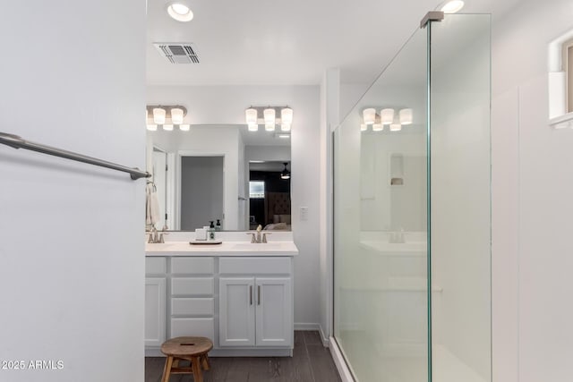 full bath featuring visible vents, a stall shower, a sink, and double vanity