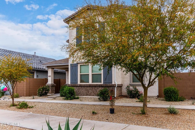 view of front of home featuring stucco siding and fence