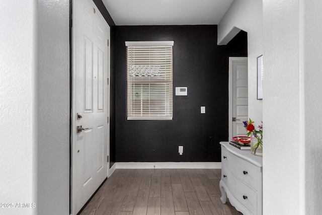 corridor featuring wood finished floors and baseboards