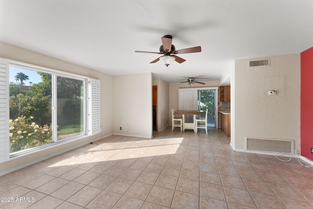 tiled spare room with ceiling fan