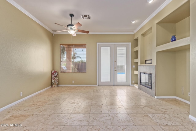 unfurnished living room with french doors, ornamental molding, a tiled fireplace, and built in features