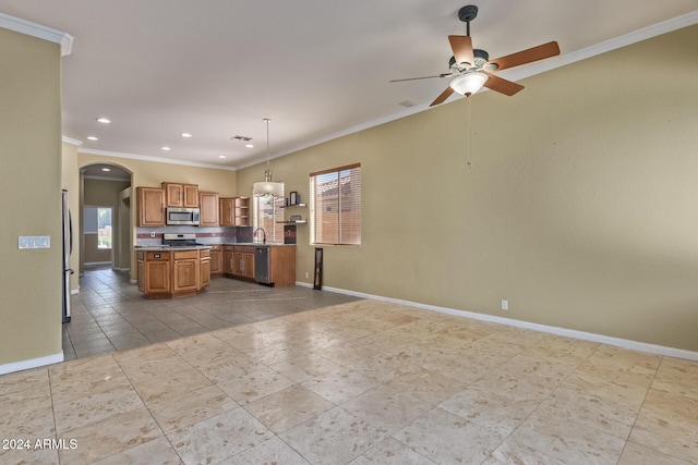 kitchen featuring sink, ceiling fan, hanging light fixtures, stainless steel appliances, and ornamental molding