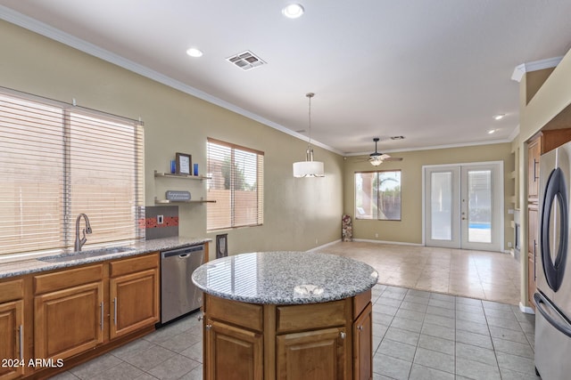 kitchen with light tile patterned flooring, appliances with stainless steel finishes, sink, and a kitchen island