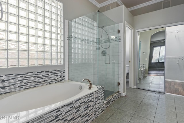 bathroom with ornamental molding, toilet, separate shower and tub, and tile patterned flooring