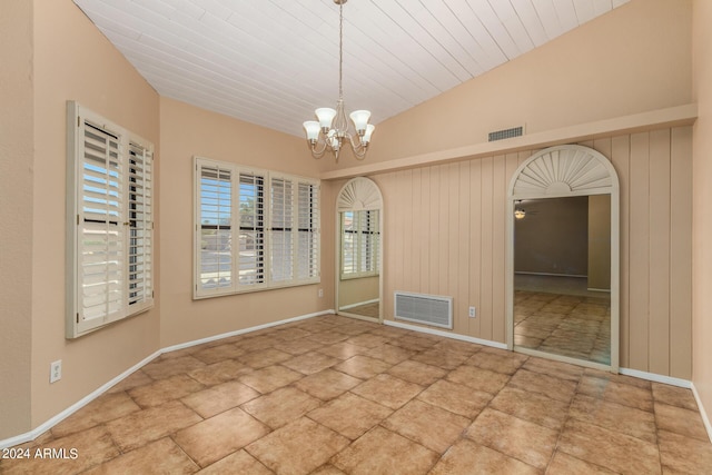 unfurnished room featuring ceiling fan with notable chandelier and vaulted ceiling