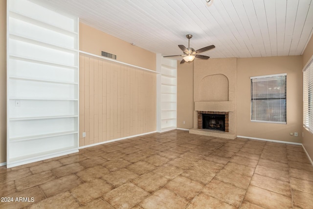 unfurnished living room with a fireplace, ceiling fan, and wooden ceiling