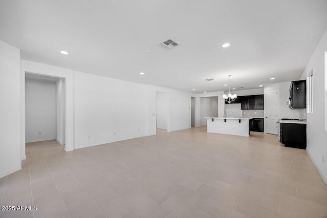 unfurnished living room featuring a chandelier