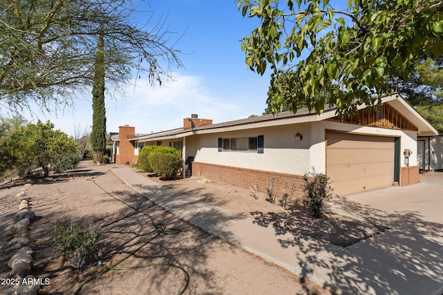 1455 W Kenrick Dr, Wickenburg, AZ 85390 - single story home featuring stucco siding, brick siding, concrete driveway, a chimney, and a garage
