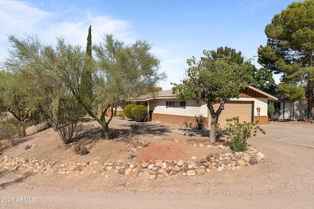 1455 W Kenrick Dr, Wickenburg, AZ 85390 - view of front of house featuring an attached garage, driveway, brick siding, and stucco siding