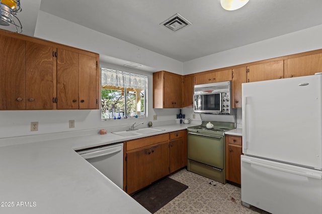 1455 W Kenrick Dr, Wickenburg, AZ 85390 - kitchen featuring white appliances, light countertops, brown cabinetry, and light flooring