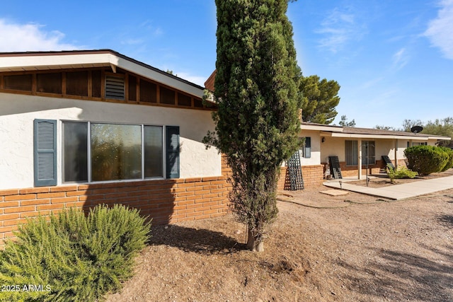 1455 W Kenrick Dr, Wickenburg, AZ 85390 - view of side of property with stucco siding, brick siding, and a patio