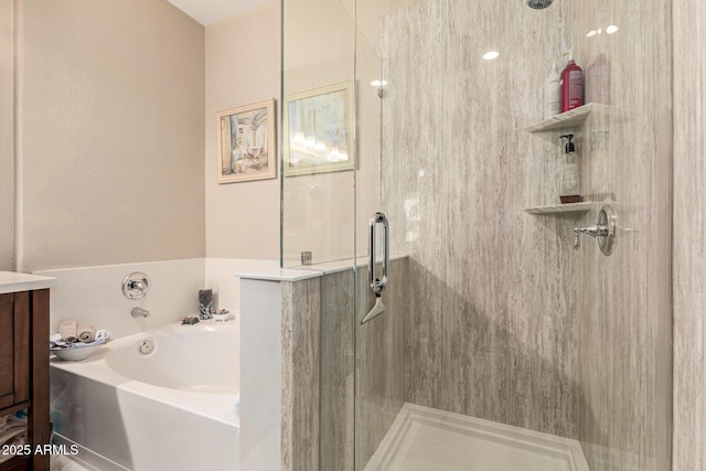 full bathroom with a garden tub, a shower stall, and vanity