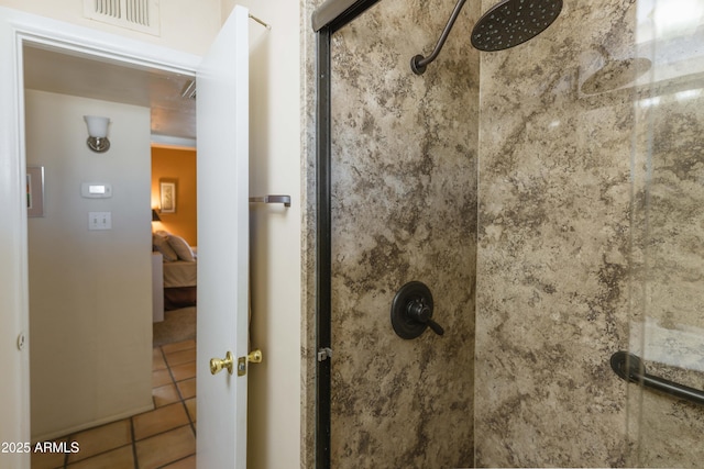 bathroom featuring a tile shower and tile patterned flooring