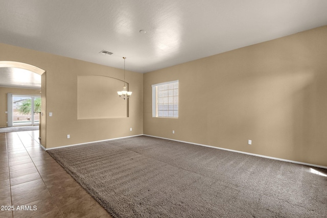 34944 N Mirandesa Dr, San Tan Valley, AZ 85143 - spare room with arched walkways, baseboards, a chandelier, and dark tile patterned floors