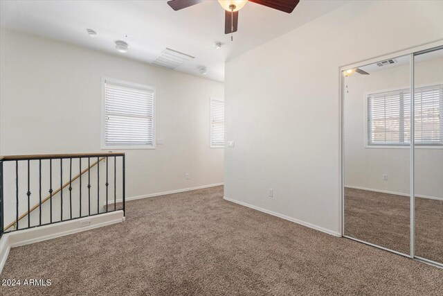 4212 E Jasper Dr, Gilbert, AZ 85296 - unfurnished bedroom featuring carpet flooring, a closet, multiple windows, and a ceiling fan