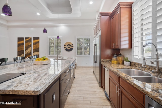 kitchen featuring pendant lighting, a center island, a tray ceiling, and sink