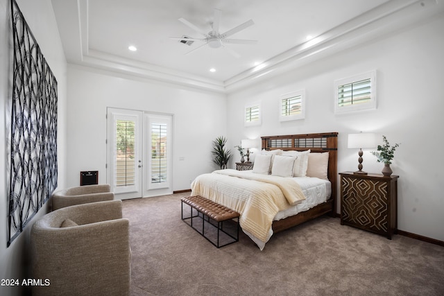 carpeted bedroom featuring ceiling fan, french doors, access to outside, and a tray ceiling