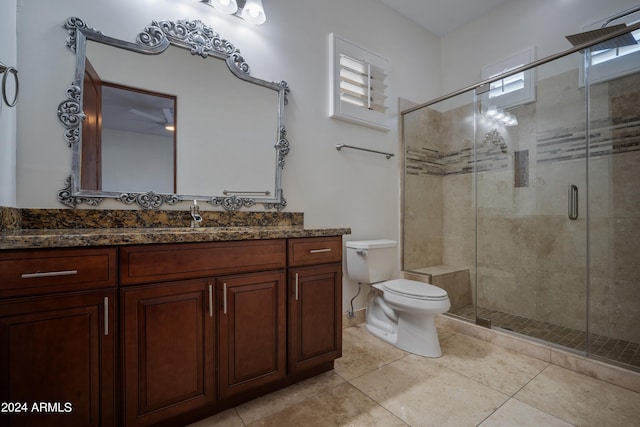 bathroom with tile patterned flooring, vanity, toilet, and a shower with door