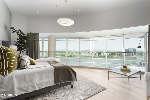 bedroom with a water view and light wood-type flooring