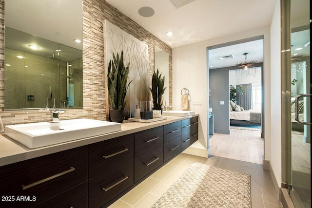 bathroom with tile patterned flooring, vanity, and walk in shower