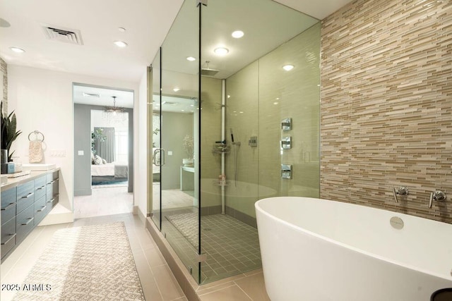 bathroom with vanity, tile patterned flooring, and plus walk in shower