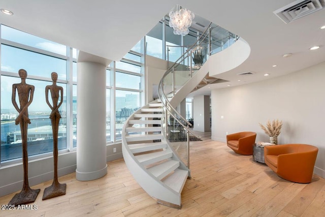 stairs featuring wood-type flooring and a chandelier